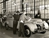 An old black and white photo of workers at a car factory