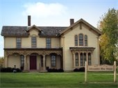 An old home with a sign reading "Alexander Blue House"