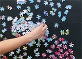 A hand putting together a puzzle