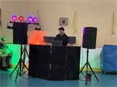 A DJ with a large speaker set and lights around him