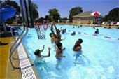 Children playing basketball in a pool