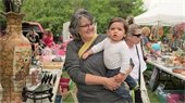 A woman holding a baby at a flea market