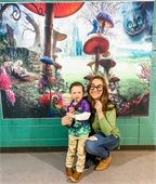 A mom and son posing in front of a photo background with props