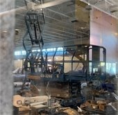A construction area with a torn down wall, tarp, and construction equipment