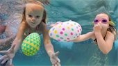 Two girls diving underwater for easter eggs